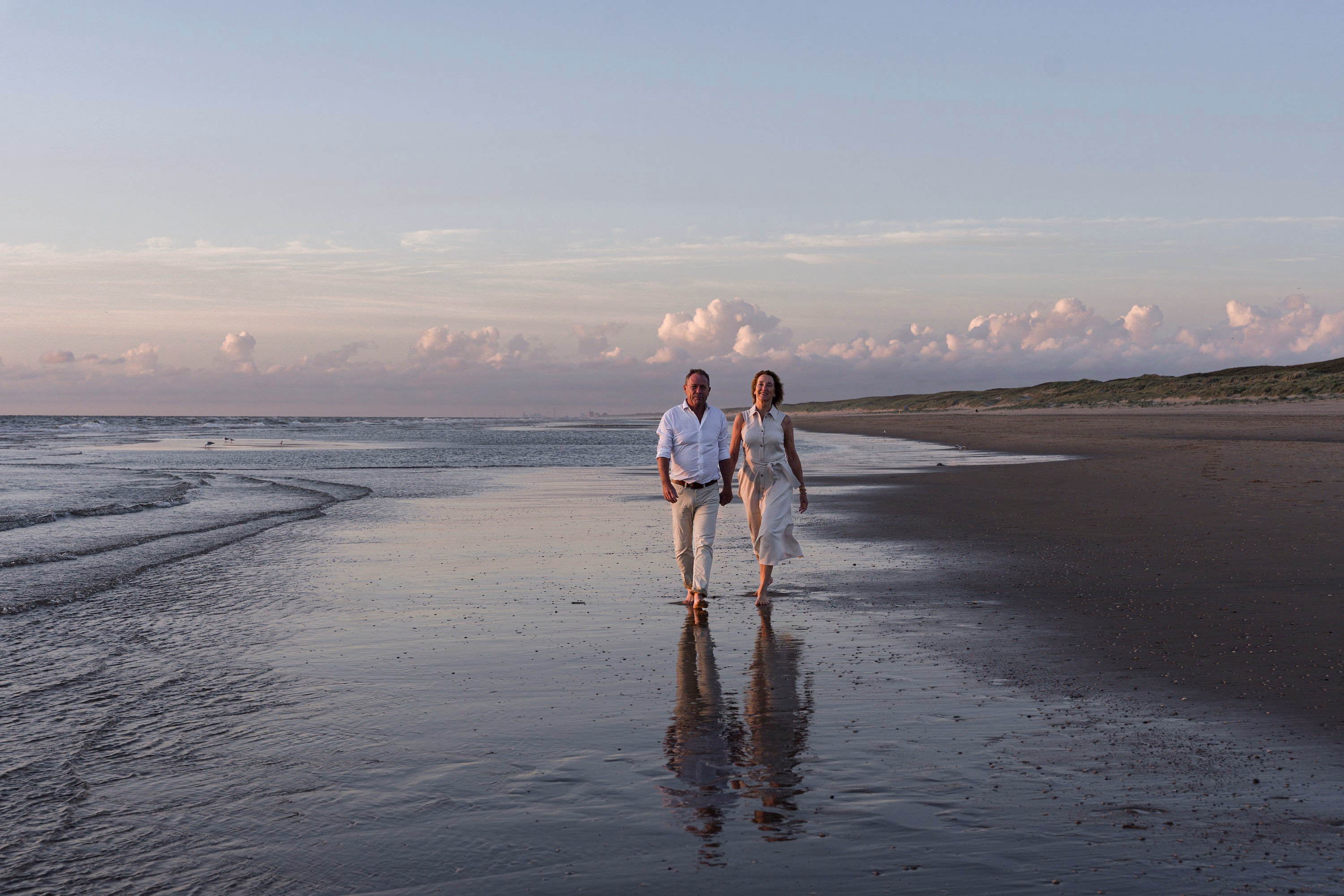 Familiefotografie Noordwijk — stel hand in hand lopend in de zee