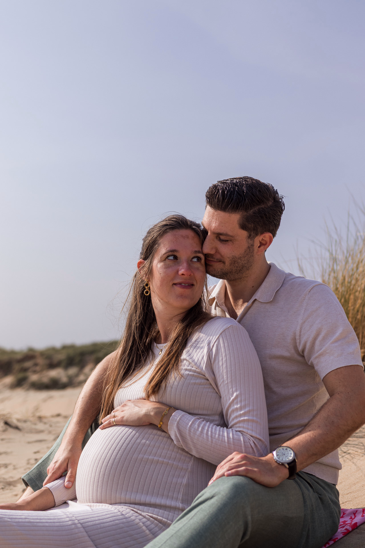 Zwangerschapsfotoshoot in Wassenaar — zwangere vrouw met partner in het zand