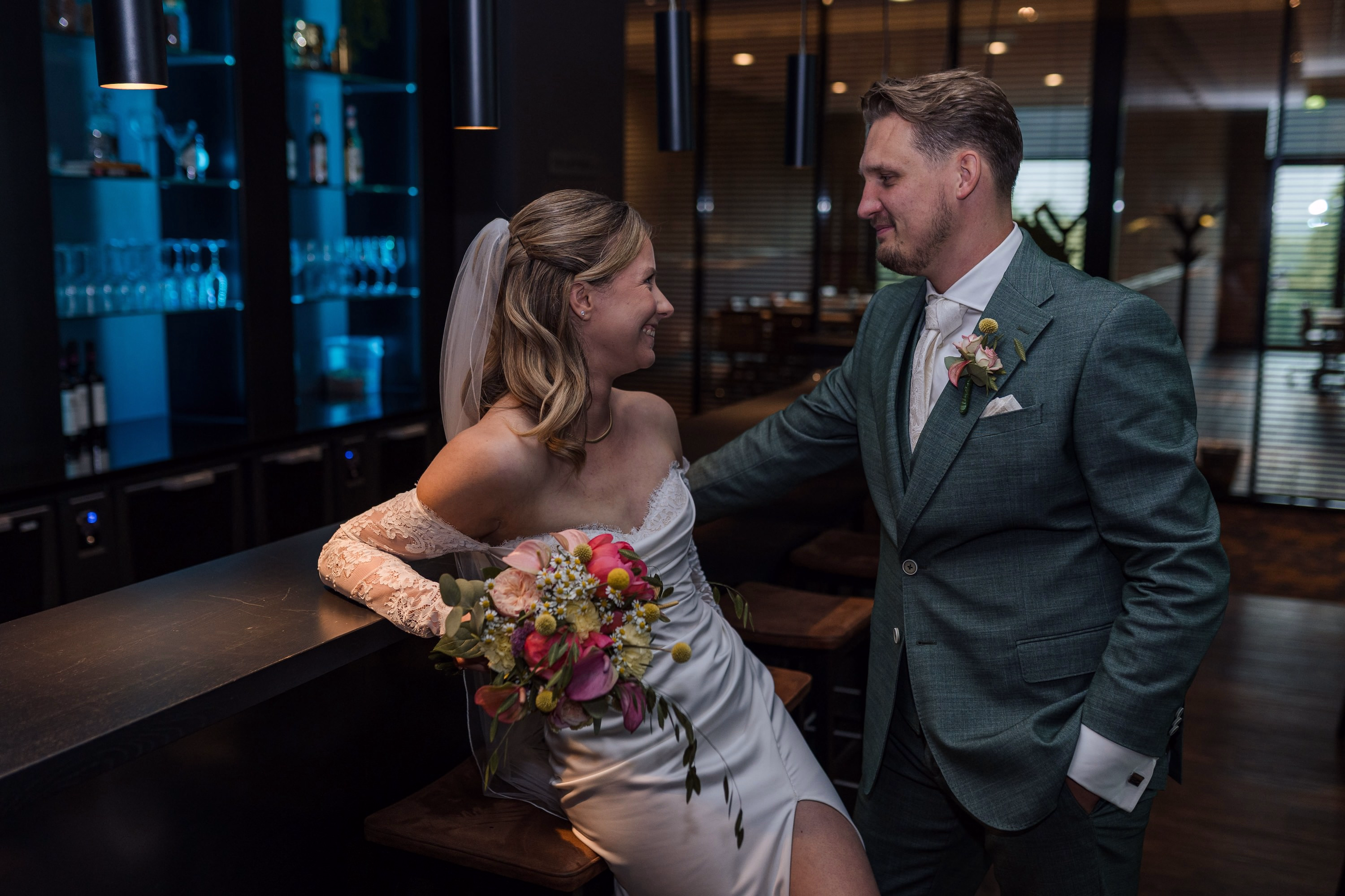 Trouwfotografie Zuid-Holland - Bruidspaar aan de bar lachend naar elkaar