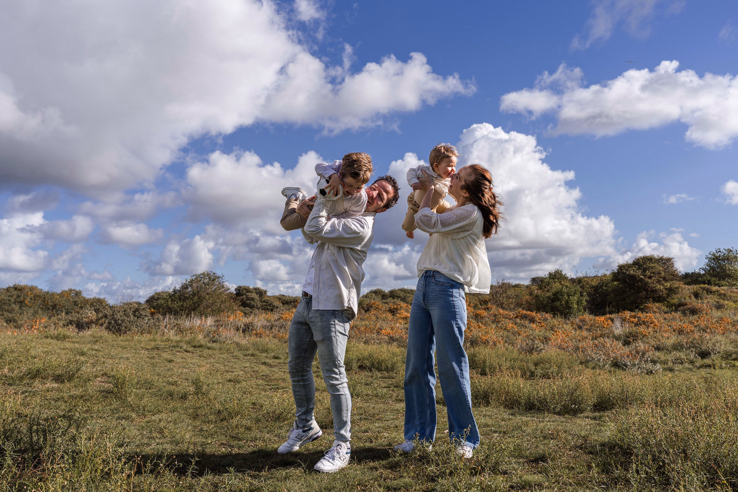 Familiefotografie Noordwijk — gezin met twee kinderen spelend in de duinen