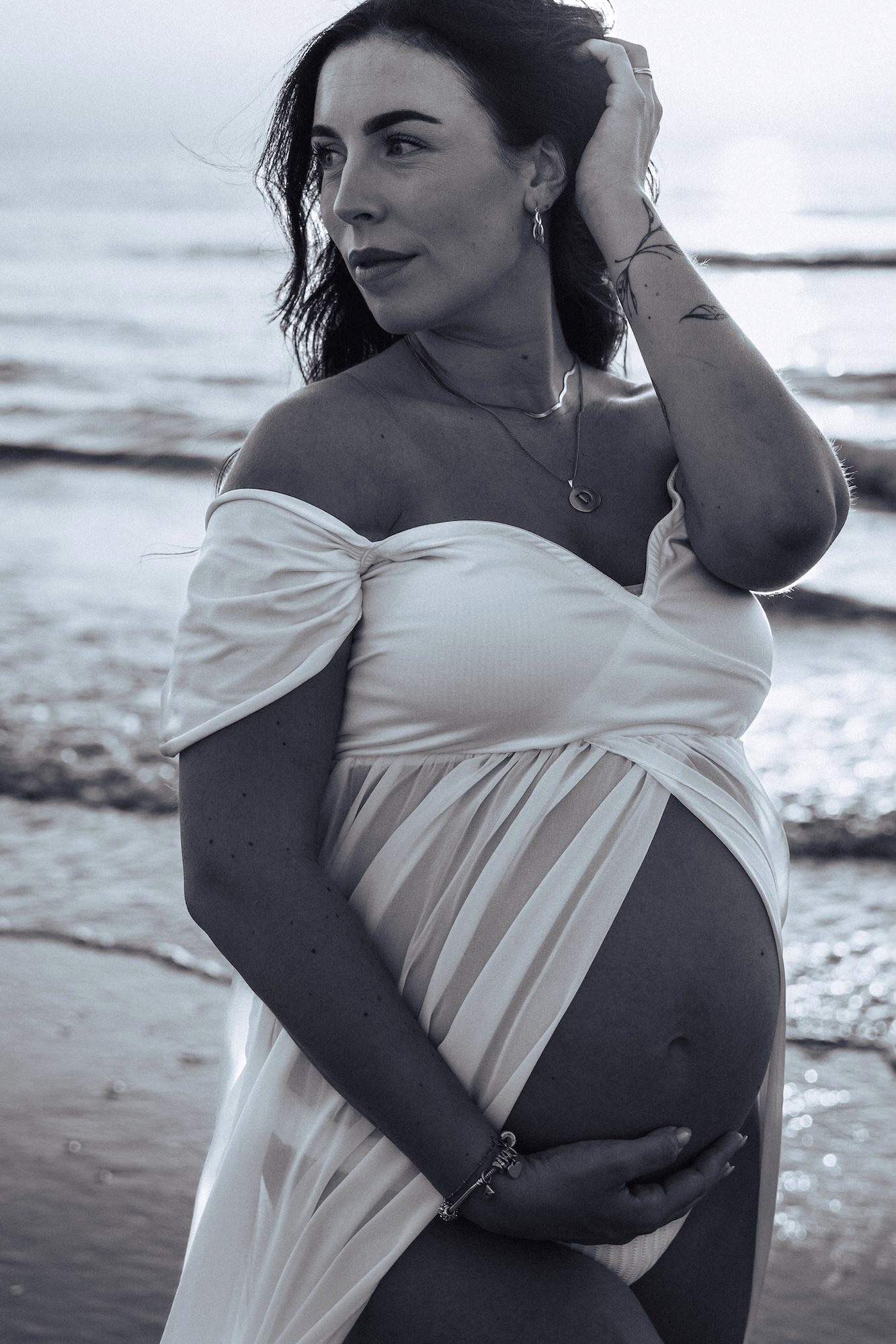 Zwangerschapsfotoshoot in Noordwijk — zwangere vrouw zwart wit met witte jurk