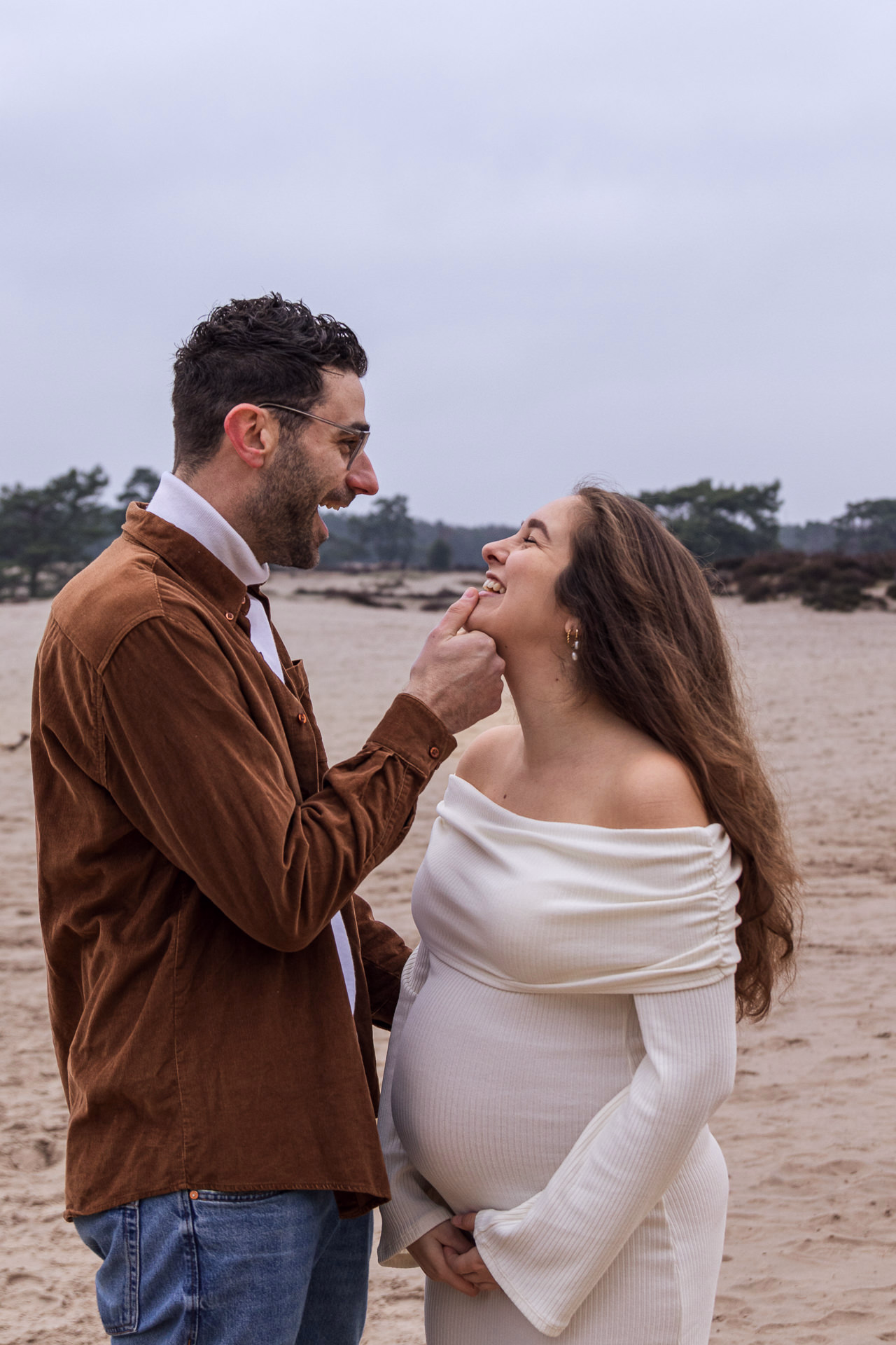 Zwangerschapsfotoshoot in Soesterduinen — zwangere vrouw witte jurk met partner