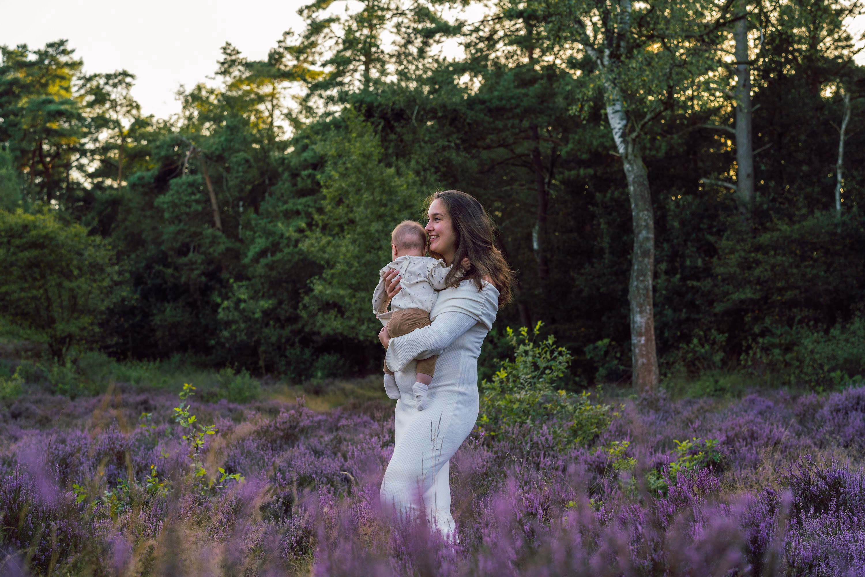 Motherhood in de paarse heide — mama met kindje en witte jurk